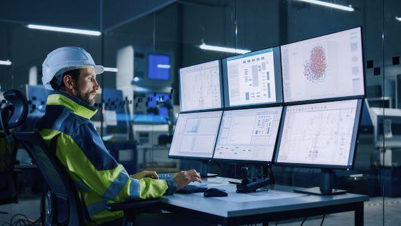 factory worker checking industrial processes on computers